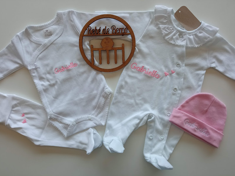 Conjunto de roupa de bebé branco e rosa com nome bordado e objeto de madeira gravado