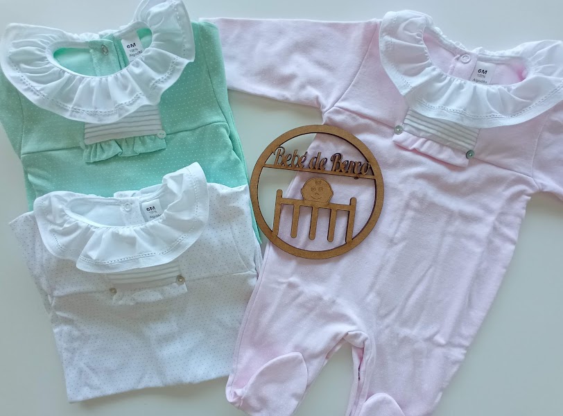 Três macacões de bebé verde, branco e rosa com gola branca decorativa e bordado, com placa de madeira 'Peito de Anjo'