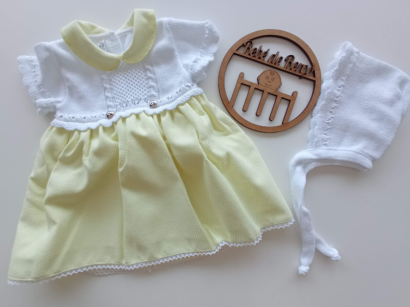 Vestido de bebé amarelo e branco, gorro branco e ornamento de madeira com texto