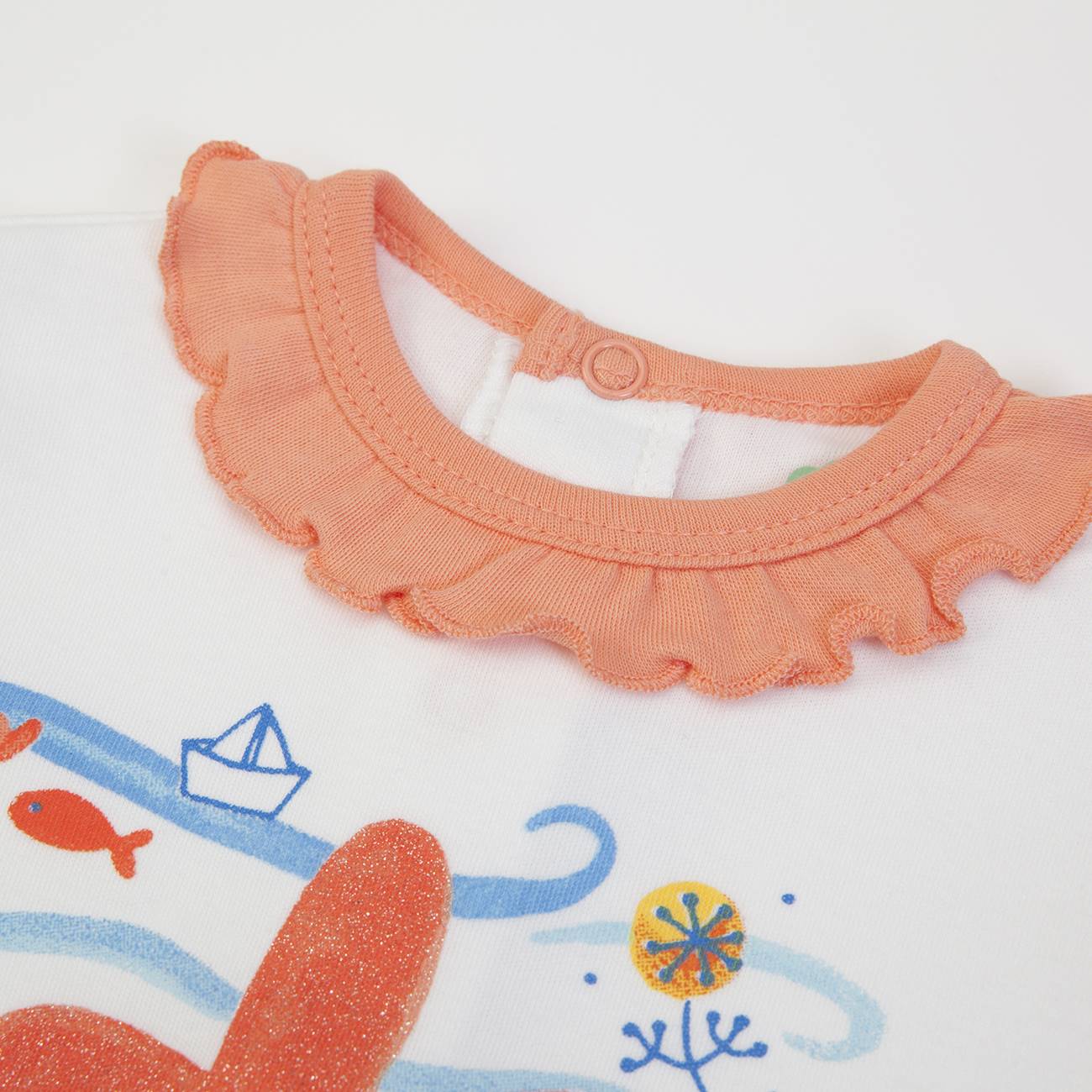 Roupa infantil branca com gola coral frisada e estampado colorido com peixe e barco de papel