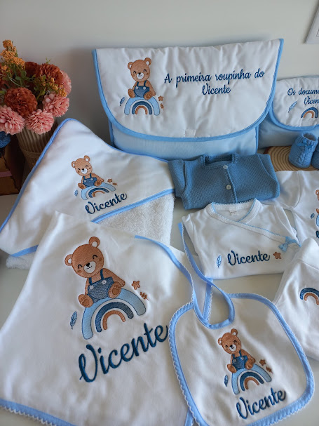 Conjunto de roupa e acessórios de bebé bordados com ursinho e arco-íris, texto Vicente e A primeira roupinha do Vicente