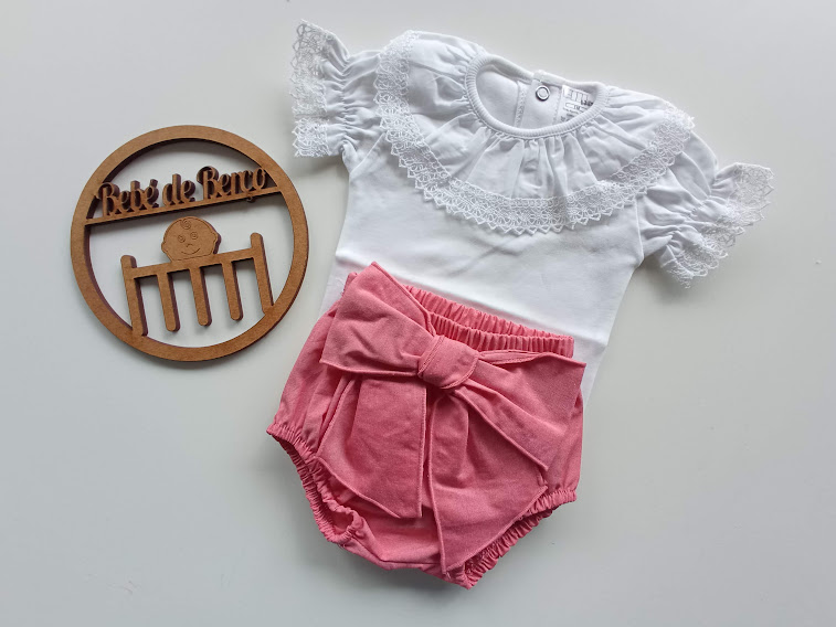 Conjunto de roupa de bebé branco com renda e calção rosa com laço