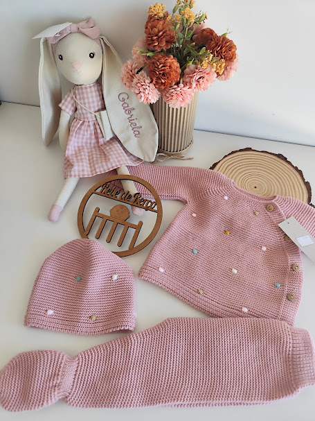 Conjunto de roupa de bebé em tricô cor-de-rosa com pompons e acessórios decorativos