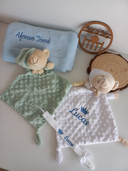 Mantas e panos de pelúcia com nomes bordados e chupeta personalizada sobre fundo branco