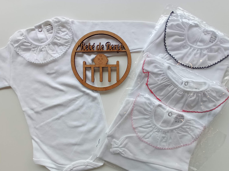 Body branco de bebé com gola bordada e bodies semelhantes embalados com placa de madeira gravada