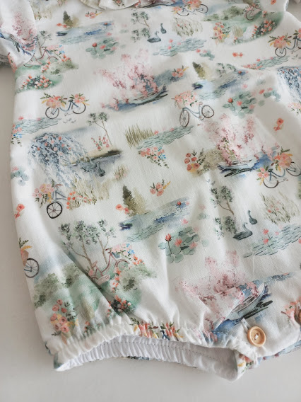 Peça de roupa com padrão de bicicletas, lagos e flores em tons pastel