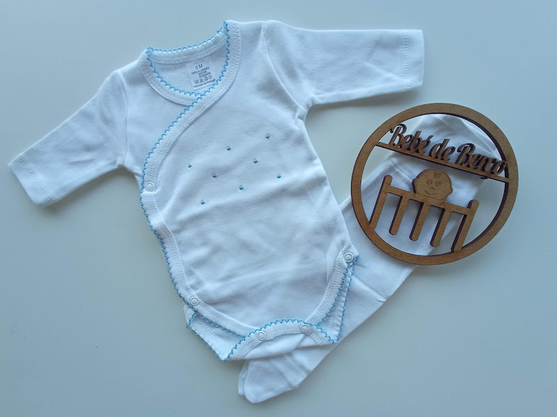 Body de bebé branco com detalhes azuis e decoração de madeira