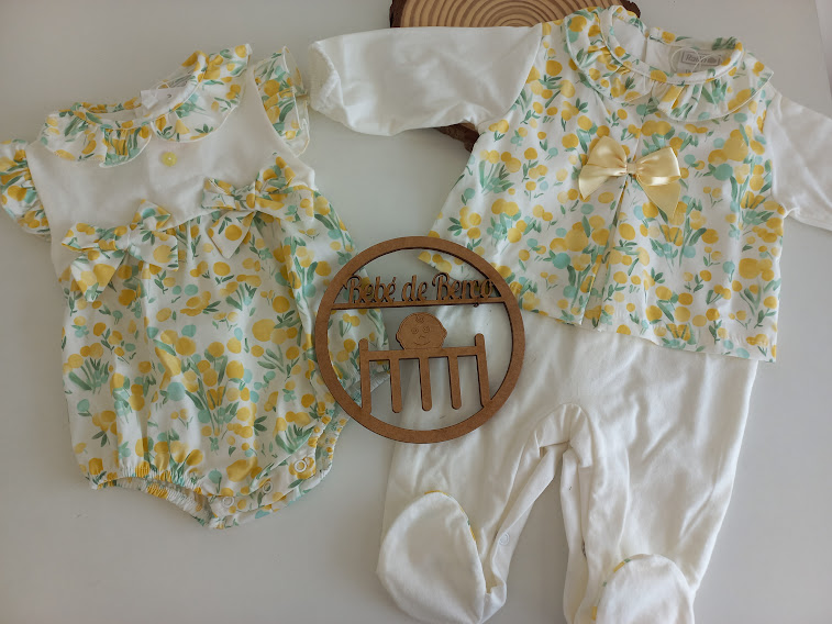 Conjuntos de roupa de bebê com padrão floral amarelo e branco e decoração de madeira com texto Pé de mesa