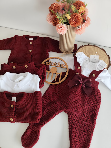 Roupa de bebé em malha vermelha e body branco com flores em vaso e placa de madeira