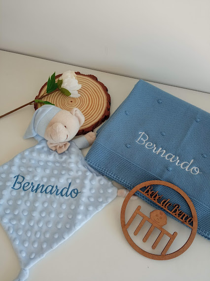 Conjunto de mantas e brinquedo azul claro com nome Bernardo bordado, com enfeites de madeira e flor branca