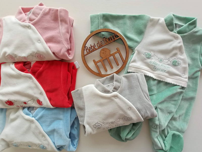 Conjunto de pijamas de bebé em várias cores com placa de madeira 'Bebé do Arraiá'