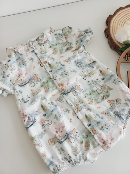 Body bebé branco com padrão de bicicletas e flores coloridas