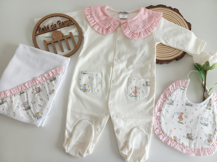 Conjunto de bebé branco com golinha rosa, babete e toalha com detalhes cor-de-rosa e padrão infantil