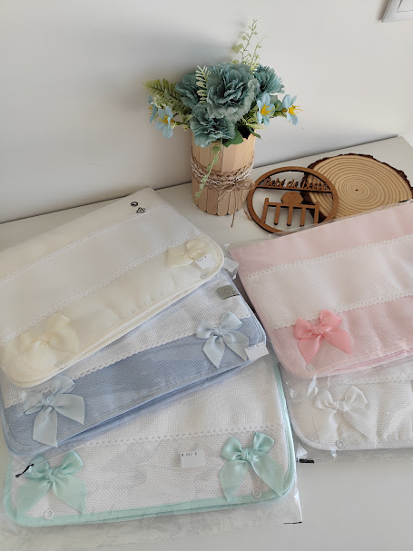 Sacos de tecido finos com laços coloridos e vaso com flores artificiais