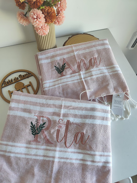 Toalhas rosa claro com riscas brancas e bordados de nomes Ana e Rita