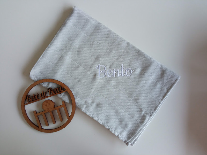 Toalha branca com bordado e suporte de madeira com texto e desenho