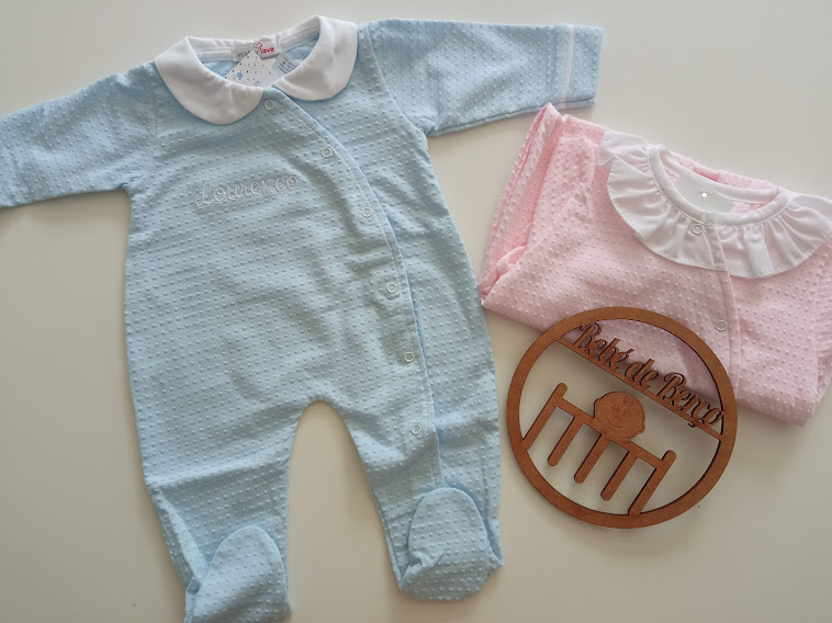 Conjunto de roupas de bebé azul e rosa com placa redonda de madeira