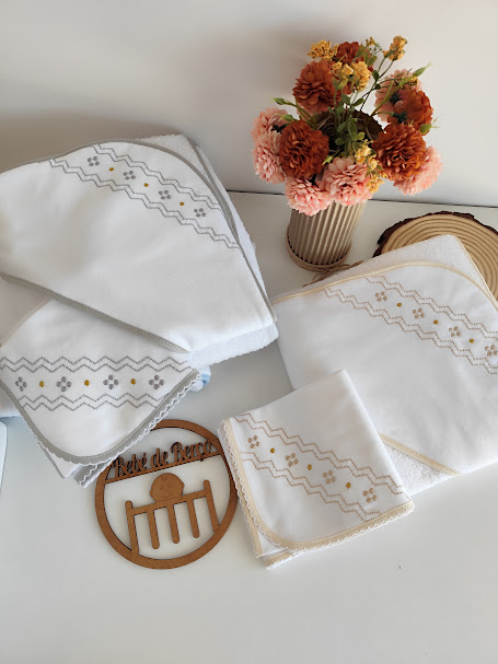 Toalhas brancas bordadas com flores e suporte decorativo em madeira