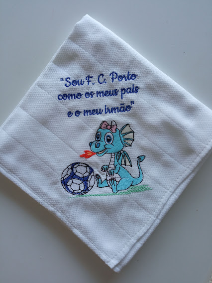 Guardanapo branco com bordado de dragão azul, bola de futebol e texto em azul