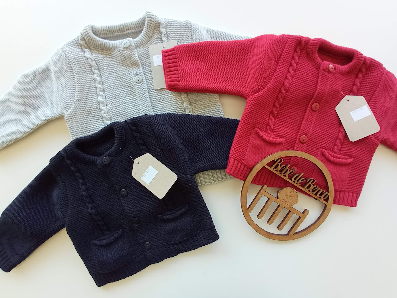 Casacos de malha para bebé em branco, vermelho e preto com etiquetas e ornamento de madeira