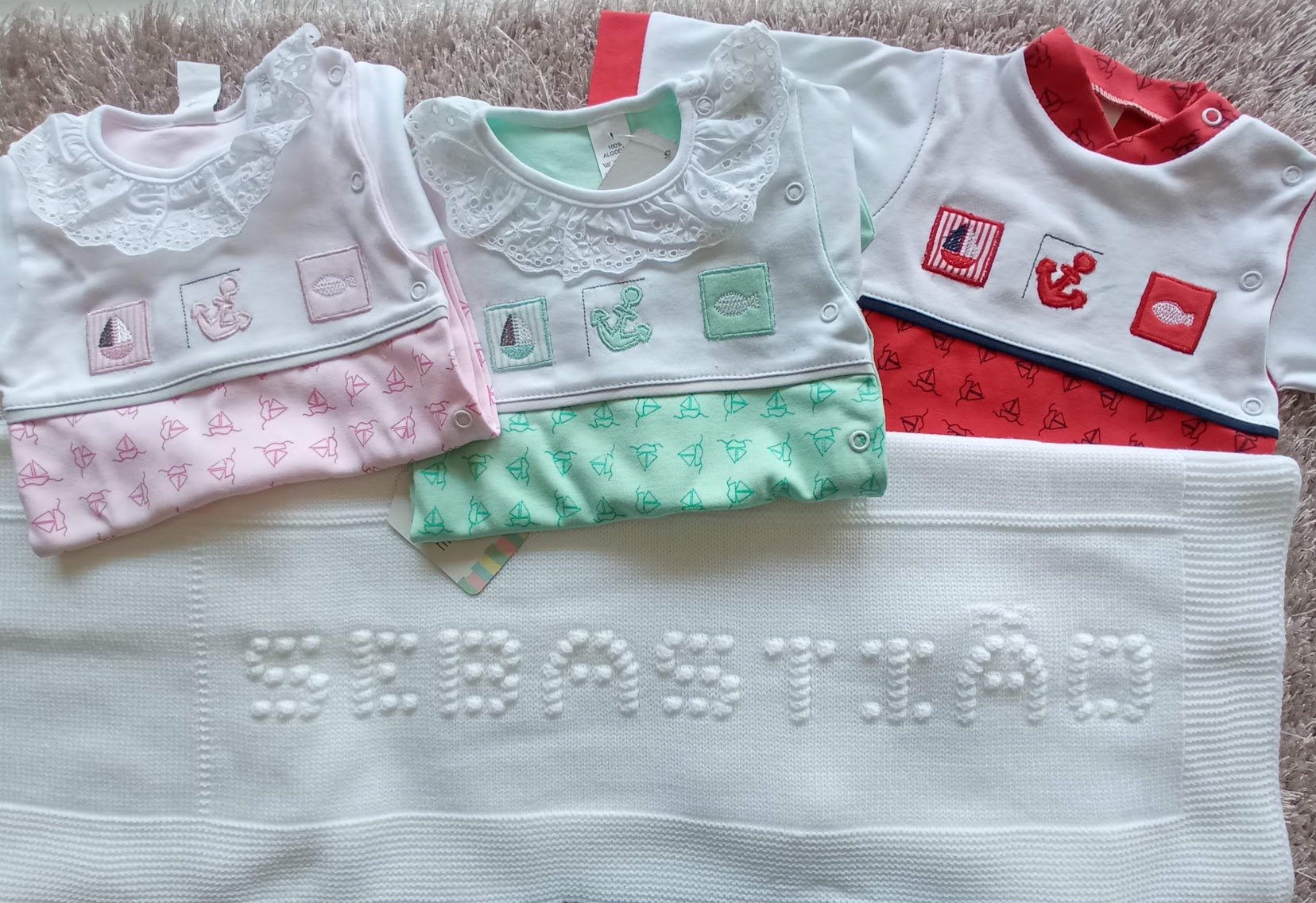 Três bodies de bebé branco com gola bordada e manta branca com nome SEBASTIÃO bordado