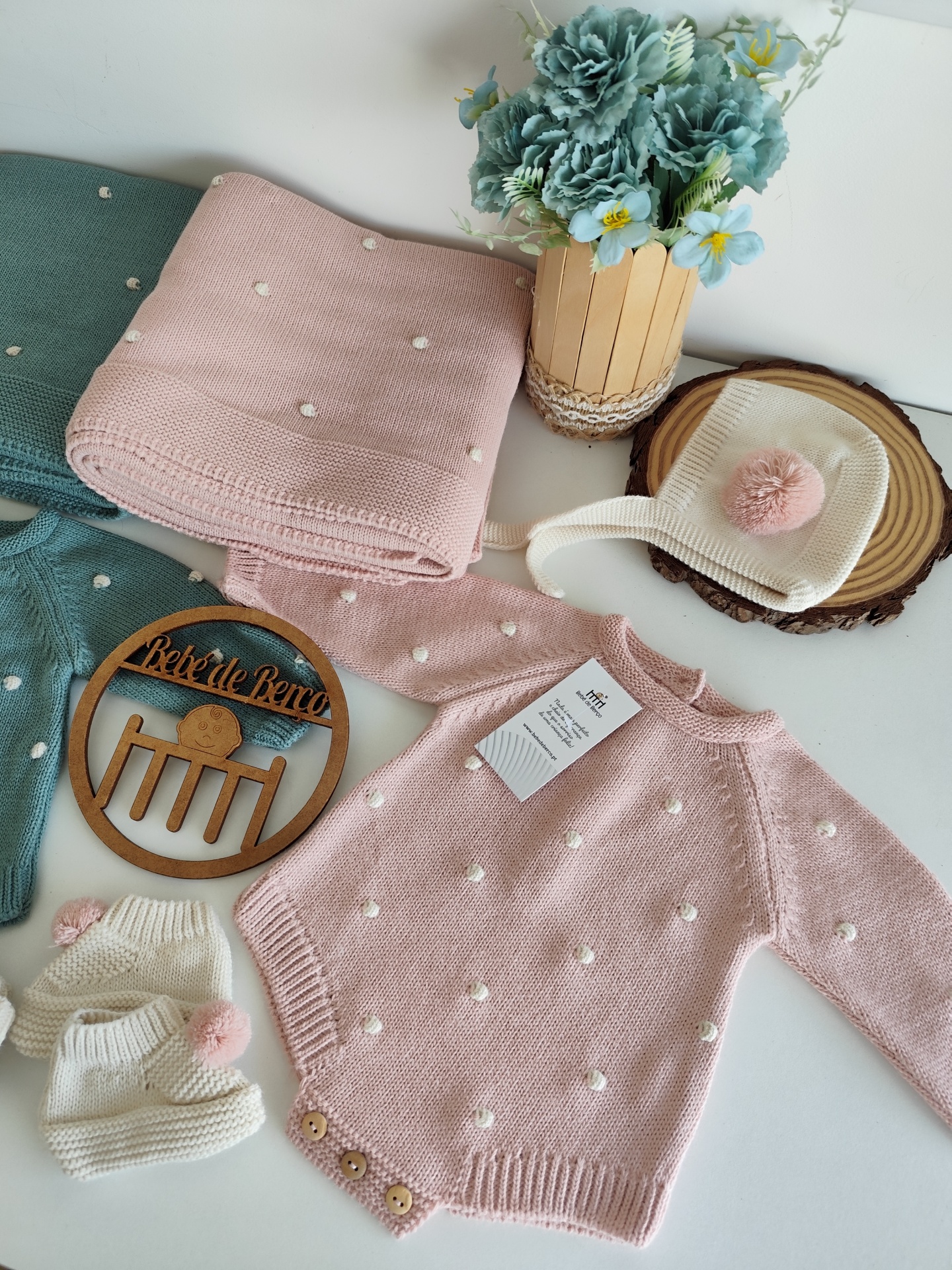 Conjunto de roupa de bebé em malha rosa e creme com pompons e bolinhas, decoração floral azul