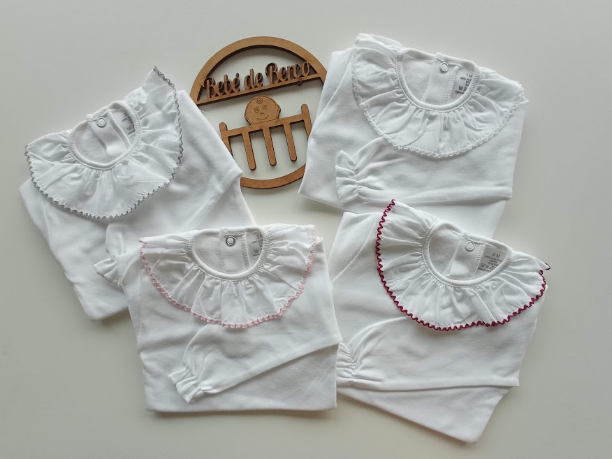 Bodies brancos para bebé com golas bordadas e placa de madeira com texto