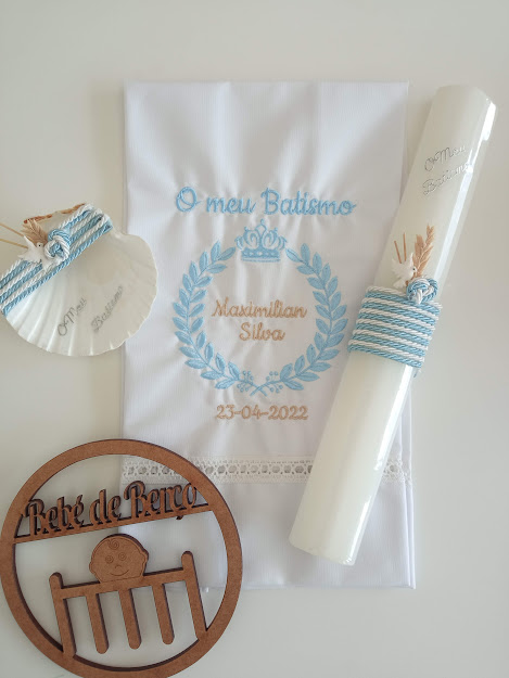 Conjunto de batismo com vela, pano bordado, concha e enfeite de madeira.