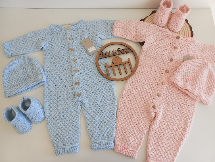 Dois macacões de malha para bebé azul e rosa com gorros e sapatinhos, ornamento de madeira com texto