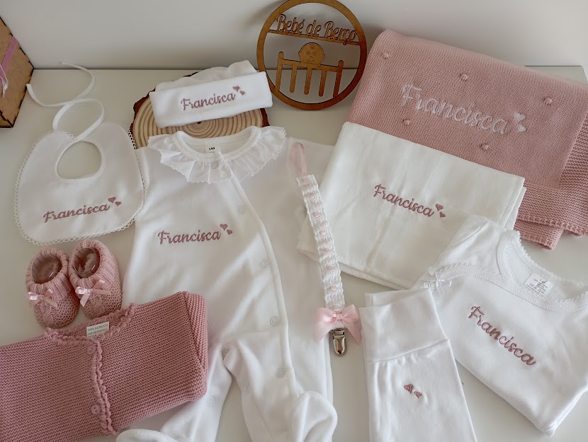 Conjunto de roupa e acessórios de bebé branco e rosa com nome Francisca bordado.