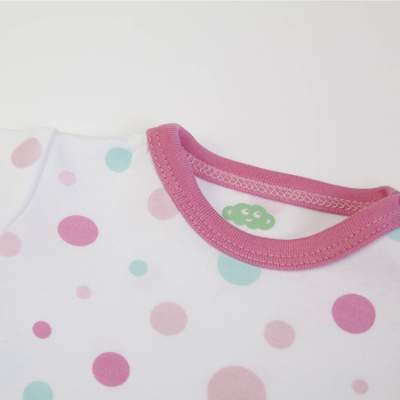 Peça de roupa branca com bolinhas coloridas e gola rosa