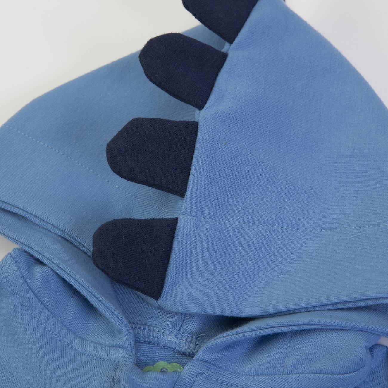 Capuz azul claro com detalhes em azul escuro em forma de espinhos em roupa de criança