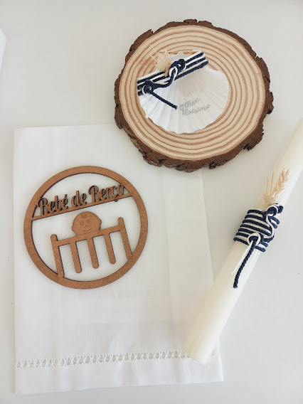 Conjunto eucarístico com toalha branca, castiçal branco e ornamento de madeira com texto e desenho, numa base de madeira redonda