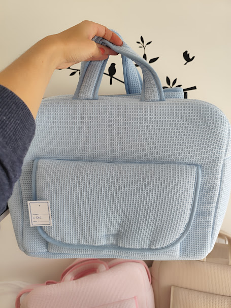 Mala azul clara com textura tipo waffle e bolso frontal