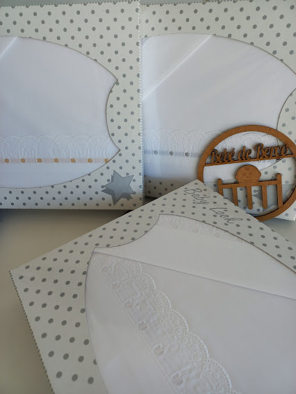 Lenços de tecido branco com bordados em embalagens brancas de pontos cinza.