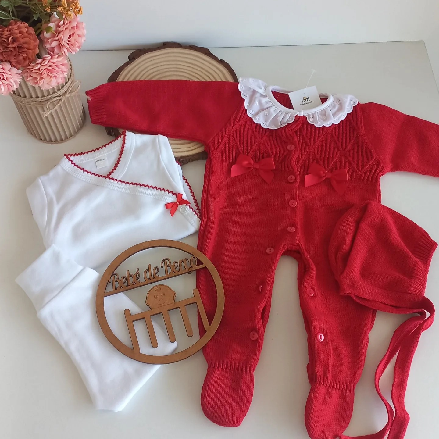 Conjunto de bebé macacão vermelho, boina e body branco com placa de madeira e flores