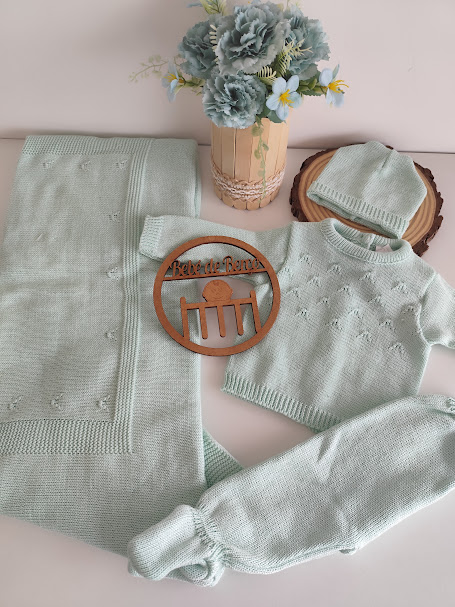 Conjunto de bebé verde água em malha com manta, casaco, calças, gorro e decoração floral.