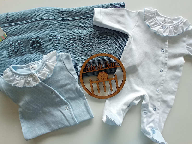 Conjunto de bebé azul claro e branco com cobertor azul e placa de madeira