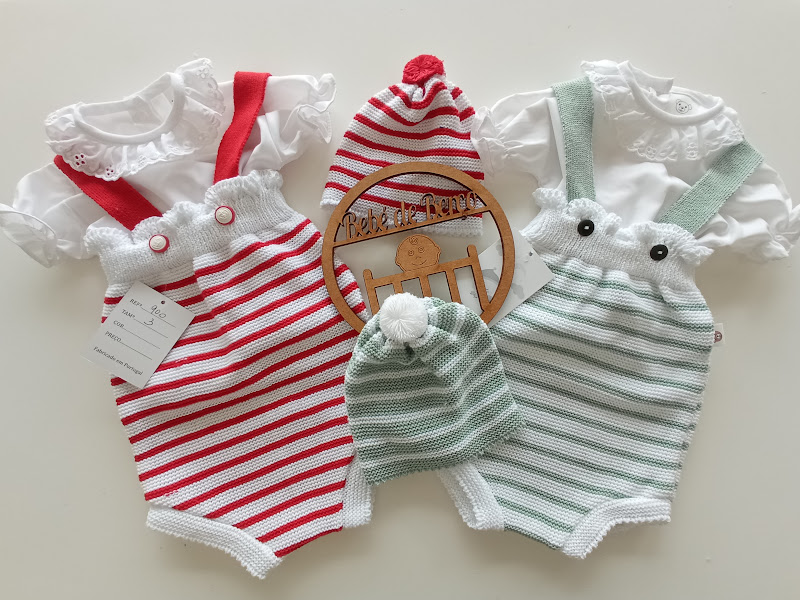 Conjuntos de roupa de bebé com jardineiras às riscas vermelhas e verdes, camisolas brancas com gola rendada e gorros às riscas com pompons