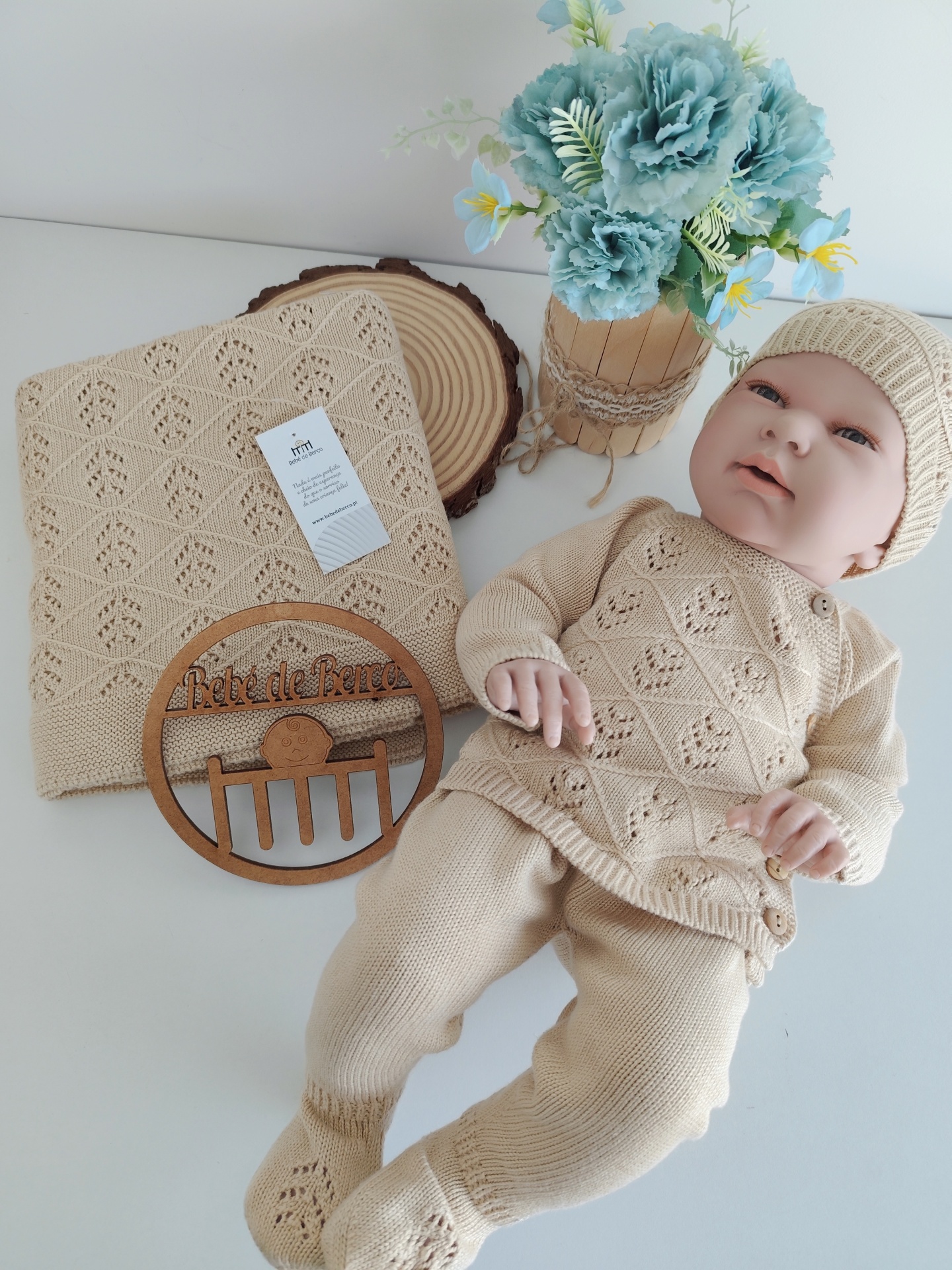 Conjunto de roupa de bebé bege tricotada com manta e placa de madeira