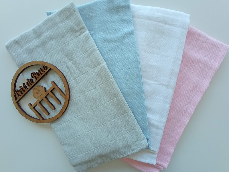 Quatro panos de chão em algodão de cores pastel e placa redonda de madeira com texto gravado