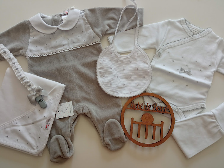 Conjunto de roupa de bebé com macacão cinza, body branco, babete branco, chucha com fita e lenço brancos