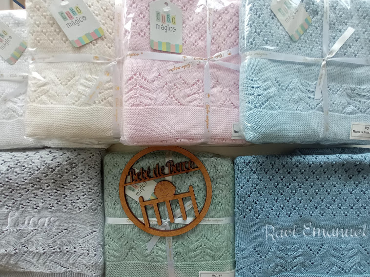 mantas de malha para bebé em várias cores e texturas com etiquetas e placa de madeira
