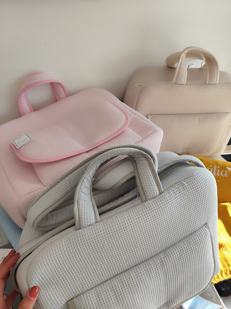 Mochilas têxteis acolchoadas em tons pastel rosa, bege e cinzento