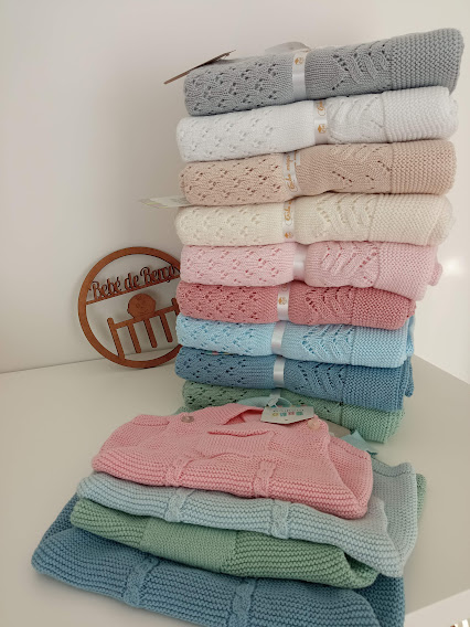 Mantas de malha empilhadas em cores pastel com decoração de madeira