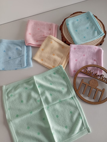 Toalhas pequenas coloridas com estrelas e suporte de madeira com texto