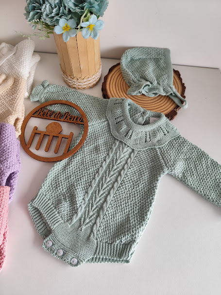 Macacão e touca de bebé em malha verde clara com padrão trançado e placa de madeira Pé de Bebé