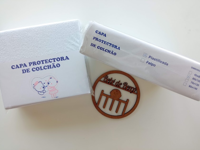 Capa protetora de colchão branca com embalagem e desenhos de crianças, texto azul