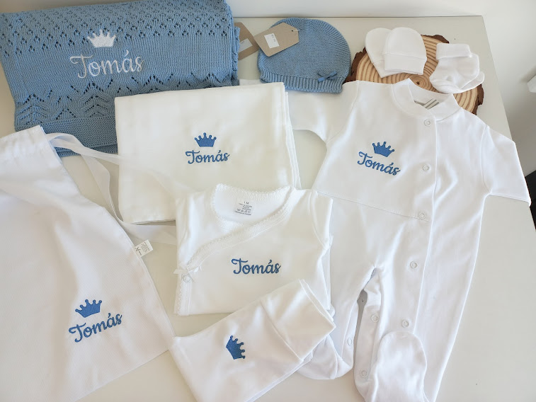 Conjunto de roupa branca para bebé com bordados azuis e manta azul tricotada