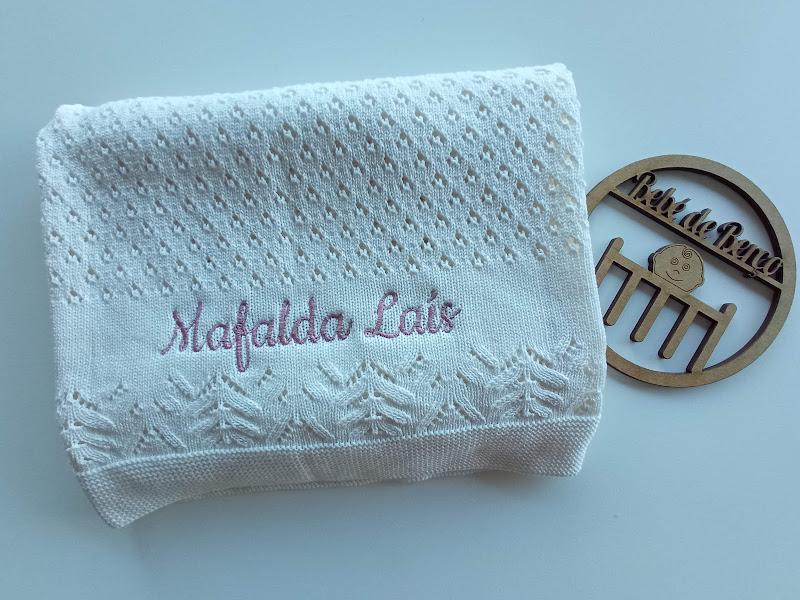 Manta branca de malha com nome bordado e crachá de madeira com texto